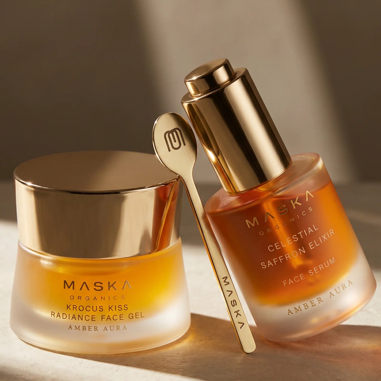 Maska Organics Saffron Symphony skincare collection featuring Celestial Saffron Elixir Face Serum and Krocus Kiss Radiance Face Gel with signature brass applicator, showcasing Ayurvedic saffron-infused skincare designed to nourish, hydrate, and promote a radiant-looking complexion.